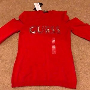 red, open-shouldered, long sleeve Guess shirt.
